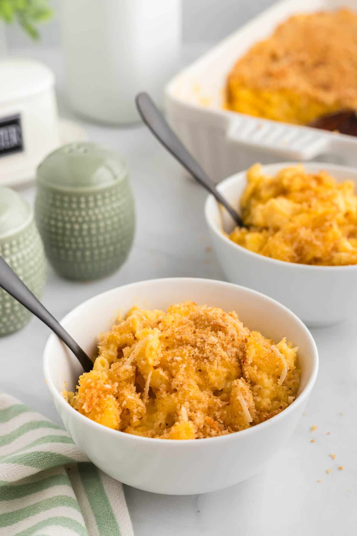 This gluten-free mac and cheese is so creamy and satisfying, with a crunchy breadcrumb topping that takes it over the edge! Two bowls of gluten free mac and cheese served in bowls.
