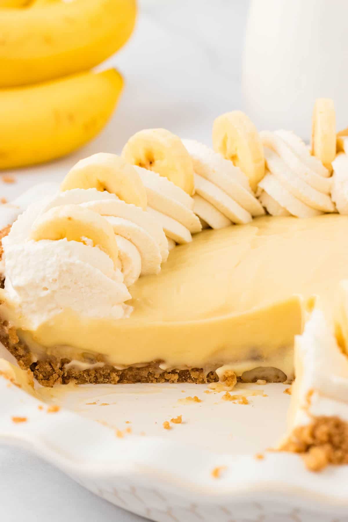 Gluten free banana cream pie with a slice taken from it.
