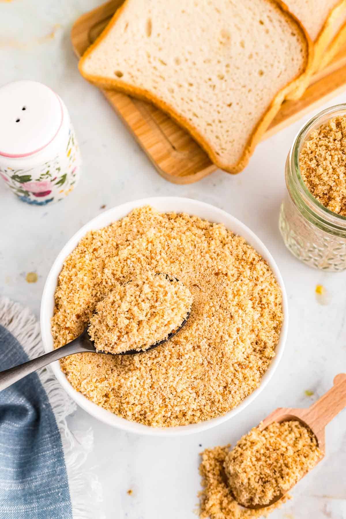 Overhead image of gluten free breadcrumbs in a bowl with a spoon.