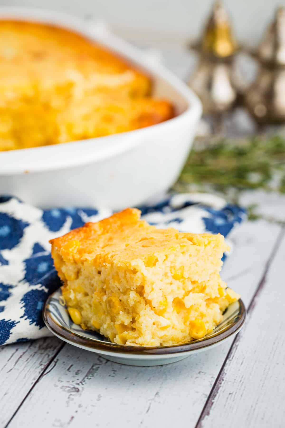 This wildly easy gluten-free corn casserole combines sweet and savory goodness with a creamy texture that’s guaranteed to be a hit. Corn casserole on a tiny serving plate.