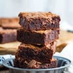 Four brownies stacked in a small metal dish with text overlay that says "Gluten Free Nutella Brownies".
