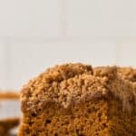 A slice of pumpkin cake with crumb topping with text overlay that says "Gluten Free Pumpkin Coffee Cake".