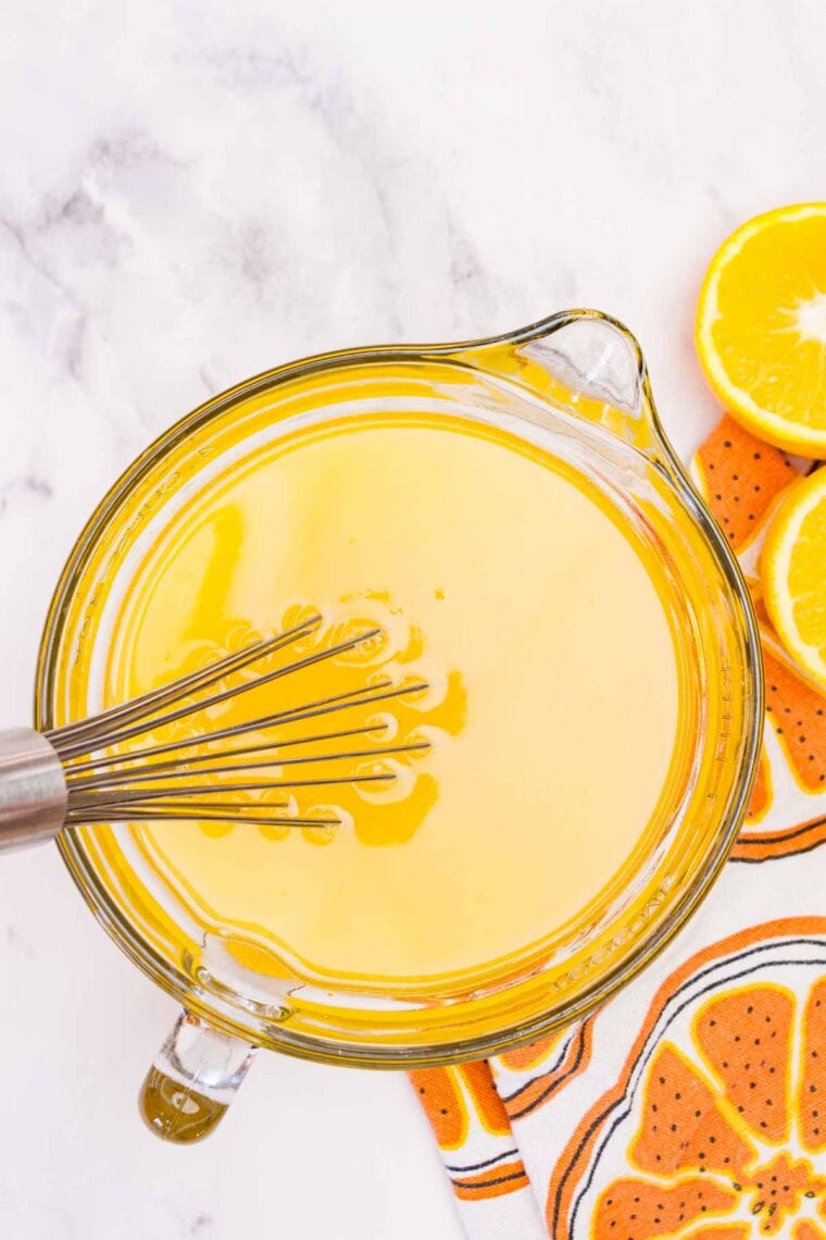 Stirring orange juice and sugar into gelatin that's been dissolved in hot water.