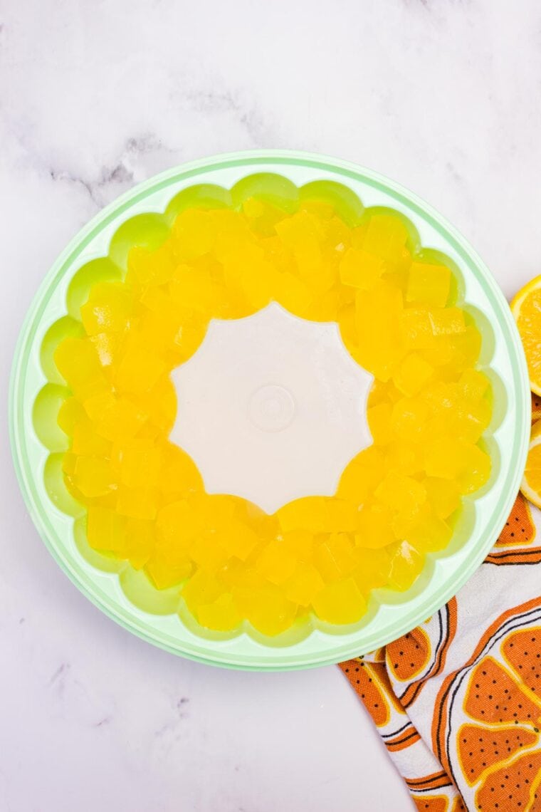 Orange jello cubes in a jello mold.