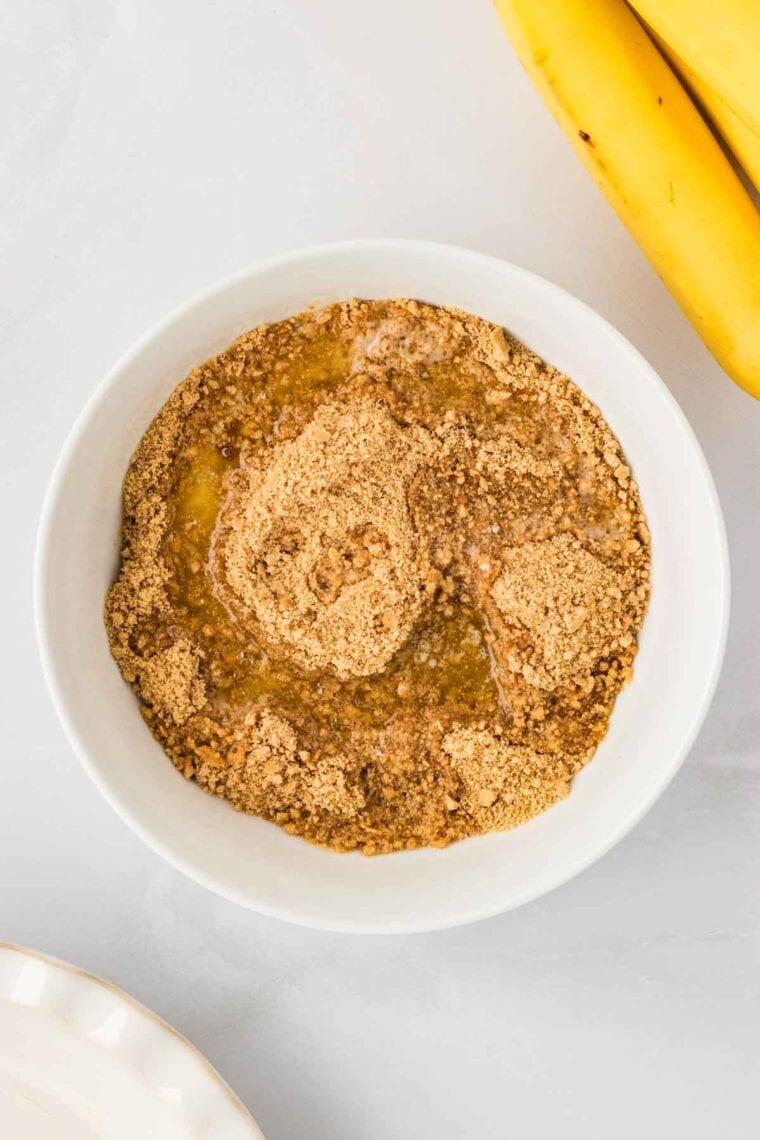 Gluten free graham cracker crumbs, sugar, salt, cinnamon, and melted butter in a bowl.