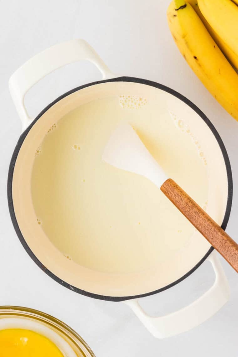 Heating a mixture of milk, heavy cream, sugar, cornstarch, and salt in a saucepan.
