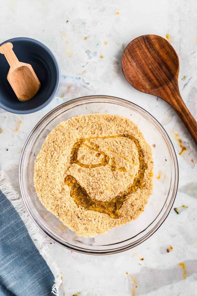 Adding olive oil to breadcrumbs.
