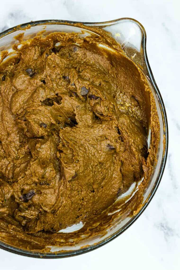 Mixing chocolate chips into gluten free chocolate pumpkin cake batter.