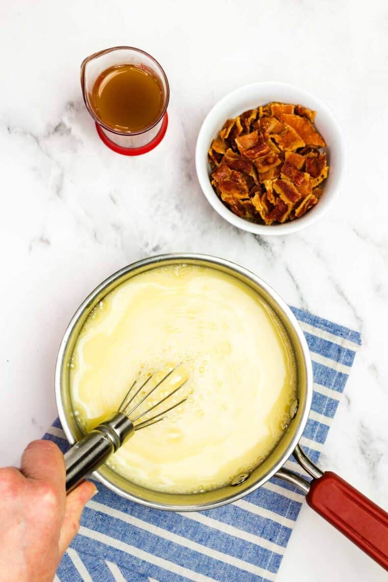 Whisking together the water, syrup, cornstarch, egg, and salt in a saucepan.