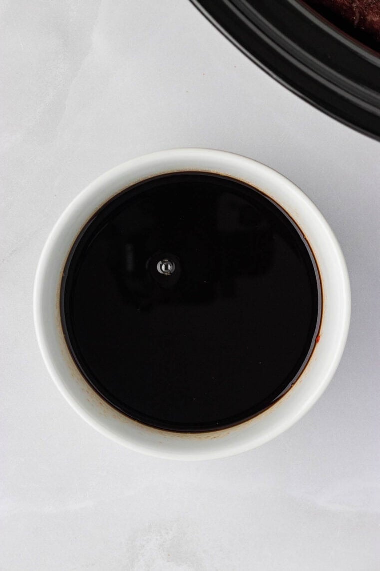 Slow cooker balsamic beef is the answer to your holiday hosting dreams, delivering melt-in-your-mouth beef in a tangy, subtly sweet sauce. A sauce of cranberry sauce, balsamic vinegar, and red wine in a bowl.