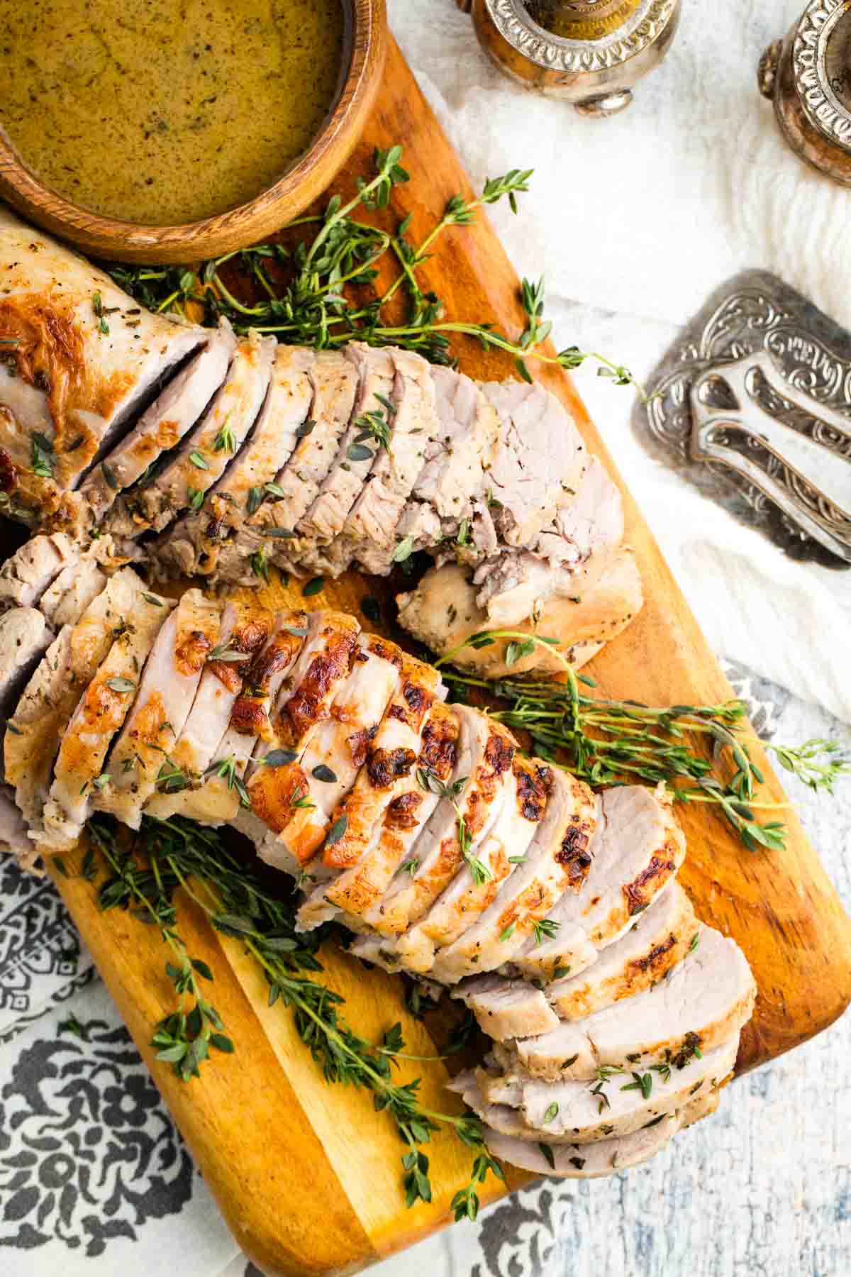 This bourbon pork tenderloin delivers tender, juicy meat with a mouthwatering maple-bourbon glaze. It'll change the way you think about pok! Overhead image of sliced bourbon pork tenderloin on a cutting board.