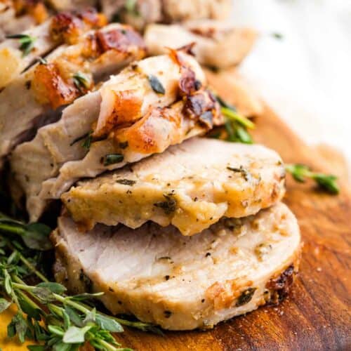 Close-up image of sliced bourbon pork tenderloin on a cutting board.