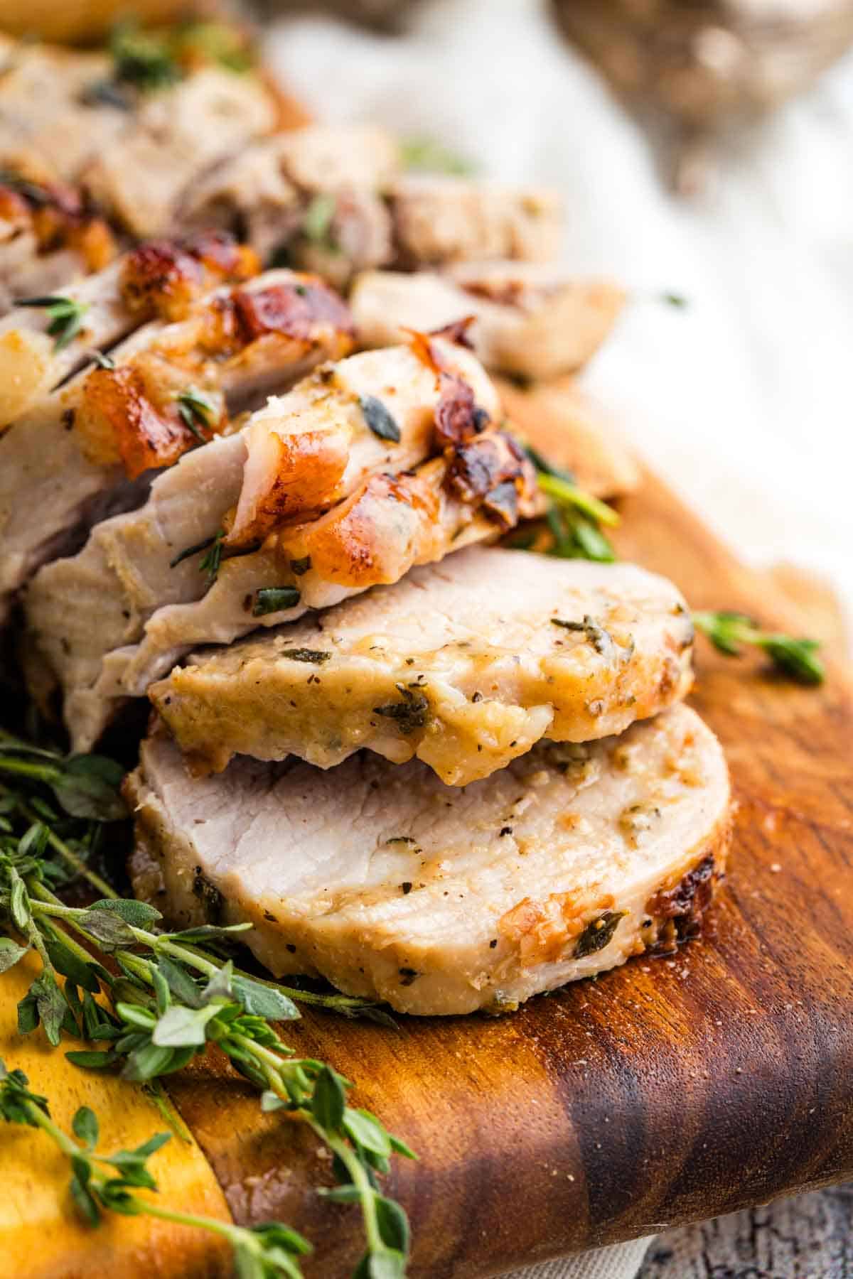 Close-up image of sliced bourbon pork tenderloin on a cutting board.