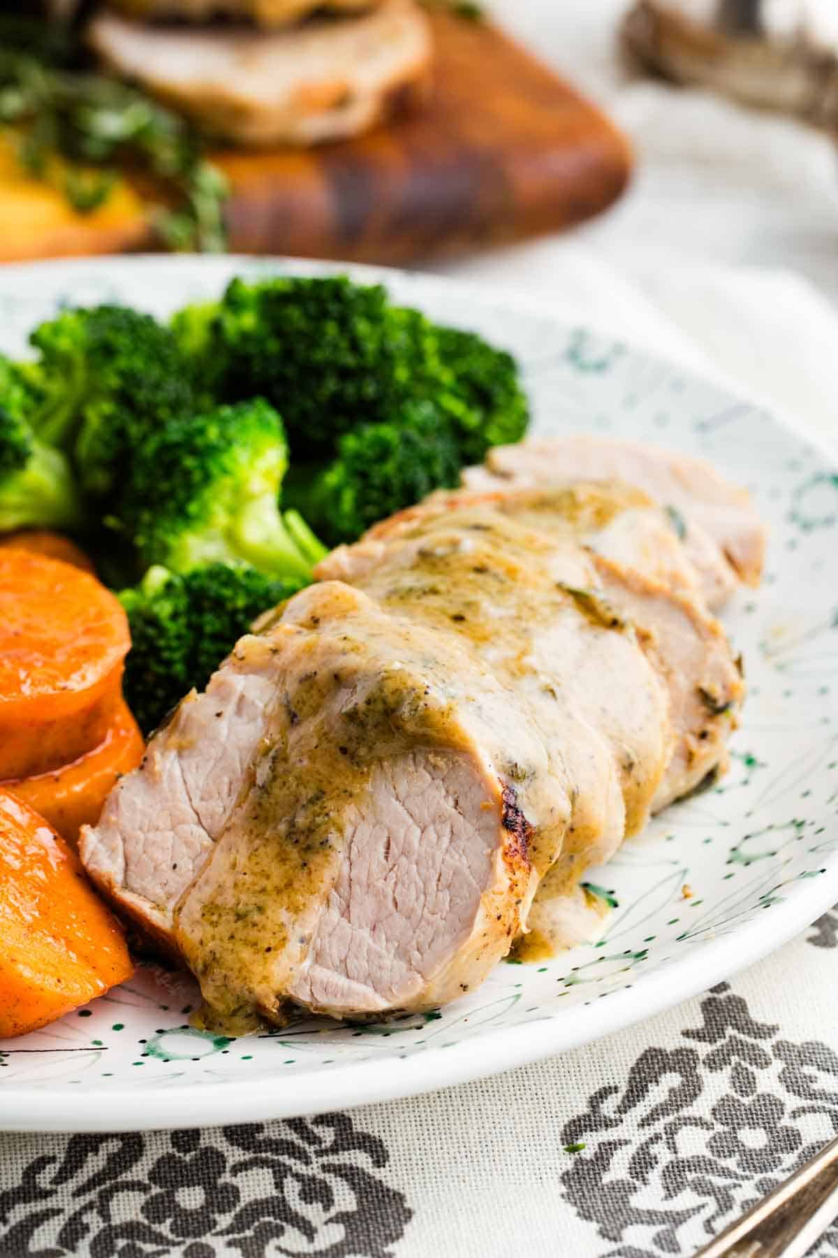 This bourbon pork tenderloin delivers tender, juicy meat with a mouthwatering maple-bourbon glaze. It'll change the way you think about pok! Bourbon pork tenderloin on a plate with broccoli and sweet potatoes.