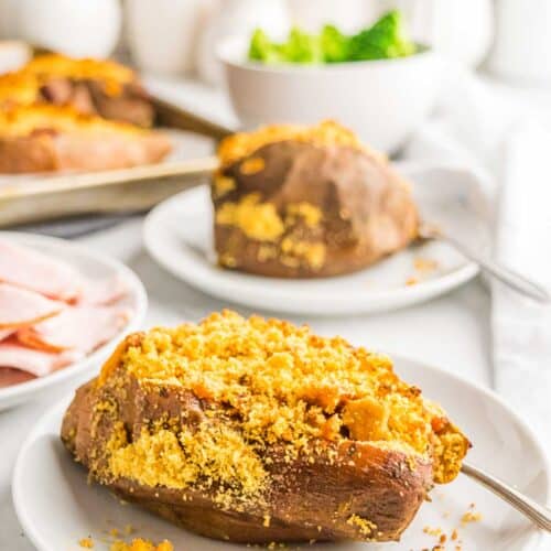 A stuffed sweet potato with crumb topping on a plate.