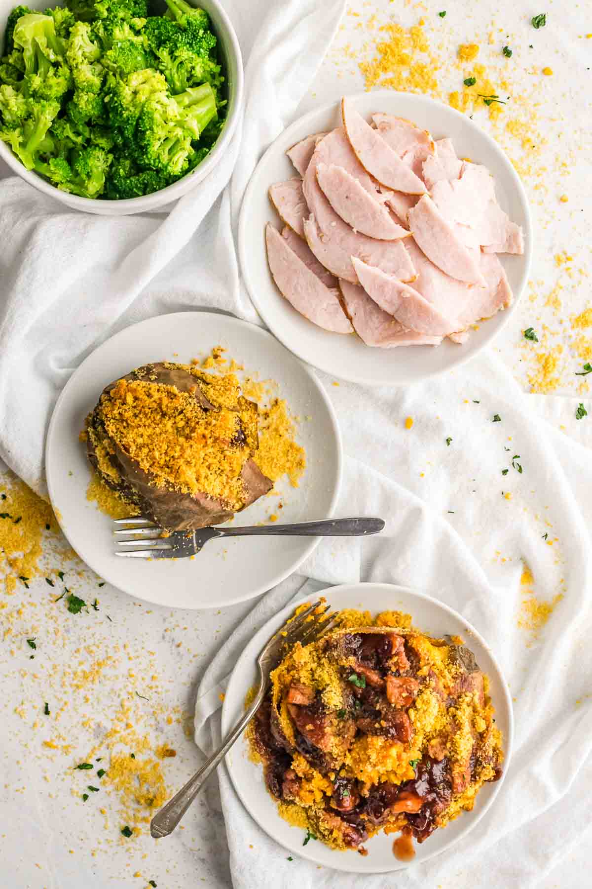 Looking down on plated of turkey stuffed sweet potatoes, turkey slices, and broccoli.