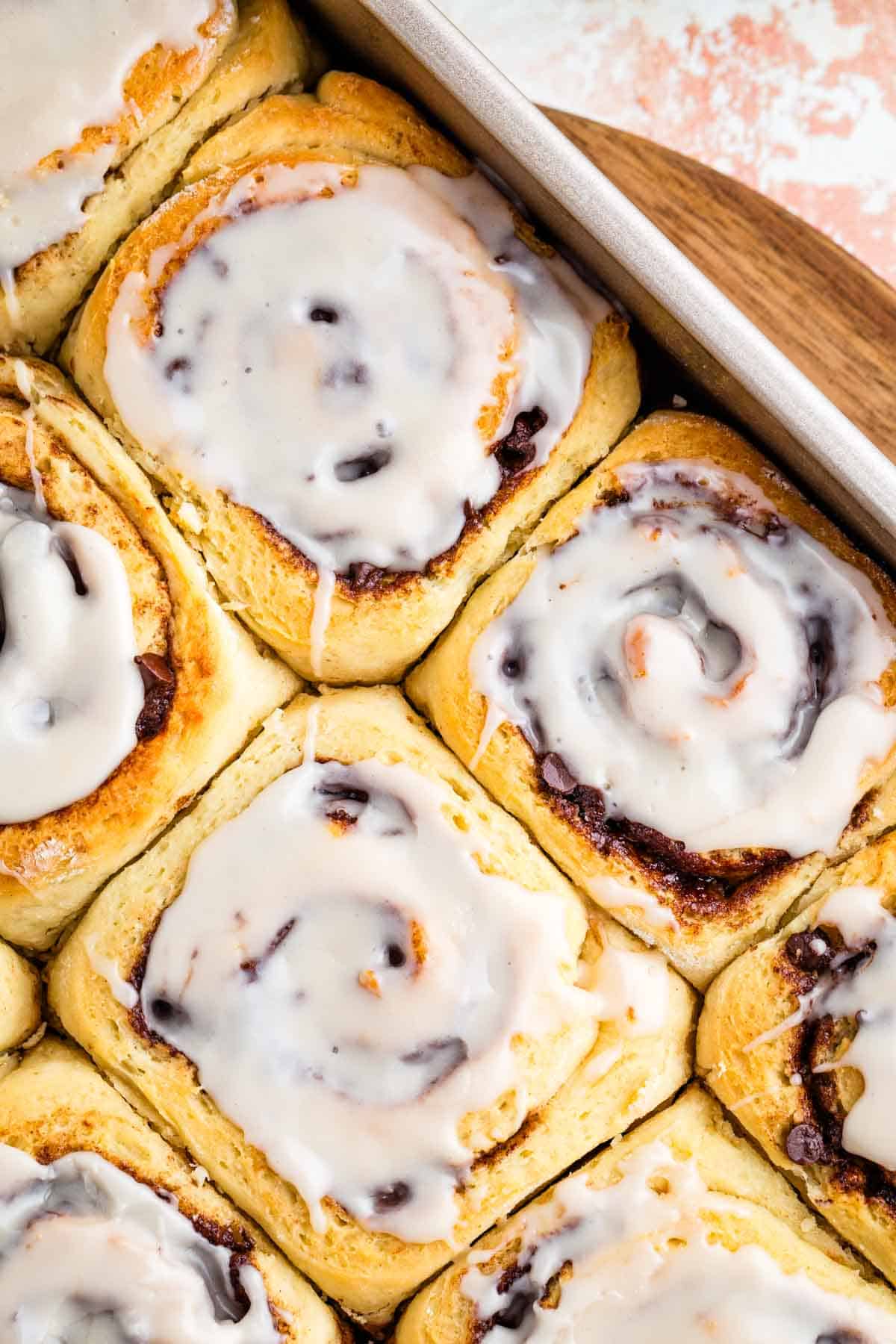 Close-up overhead image of chocolate cinnamon rolls in a baking pan.