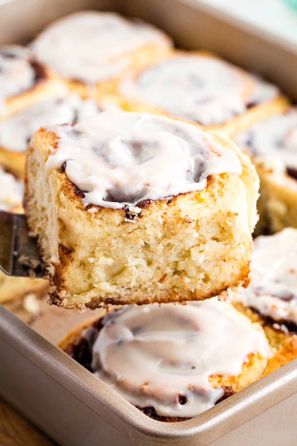 A spatula holding a gluten-free chocolate cinnamon roll up to the camera.