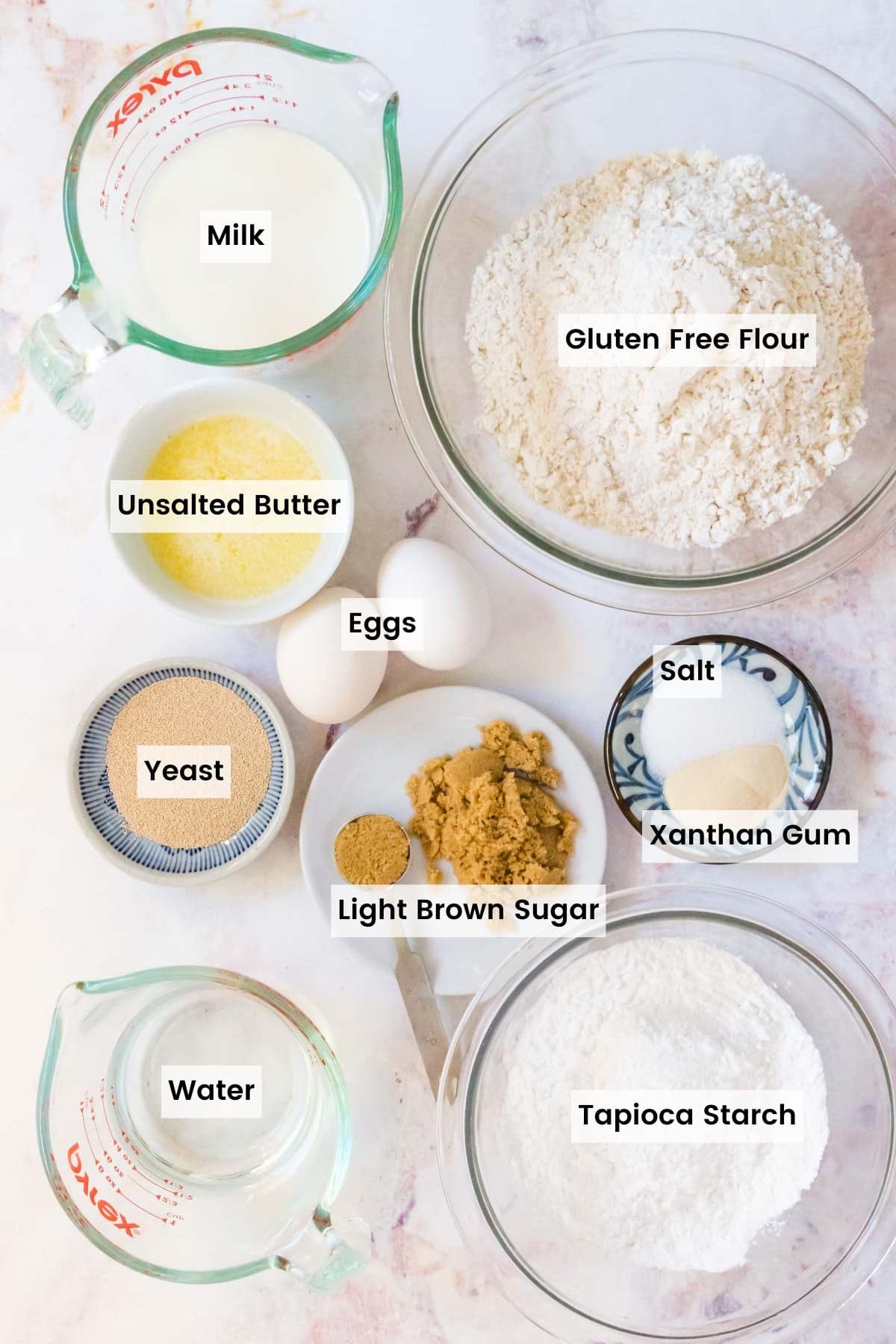Ingredients to make gluten free dinner rolls in bowls and measuring cups with text labels.