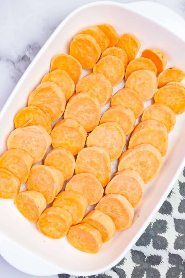 Sweet potato slices arranged in lines in a baking dish.
