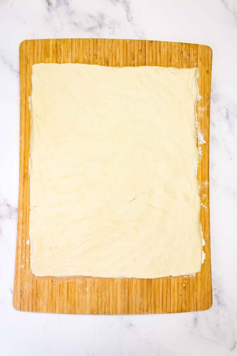 Gluten-free cinnamon roll dough pressed into a rectangle.