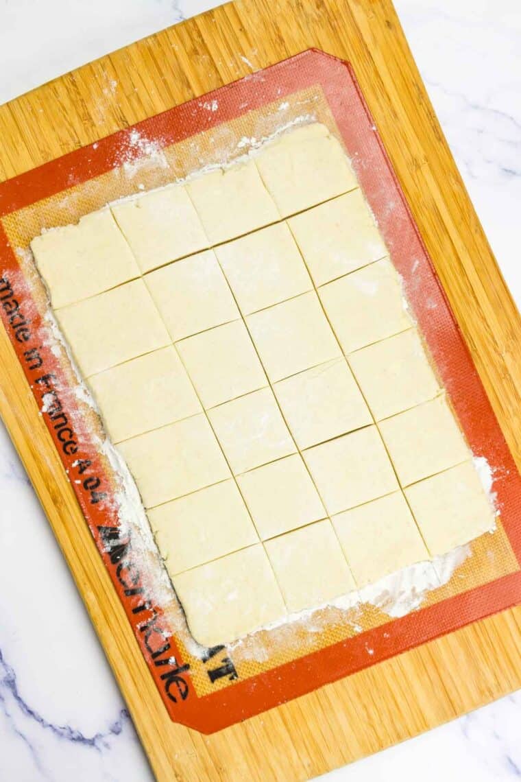 Crescent roll dough cut into squares.