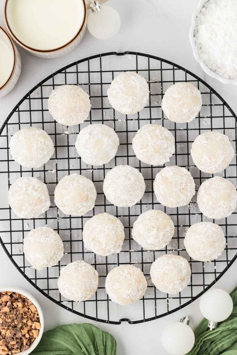 Toffee almond snowball cookies on a wire cooling rack.