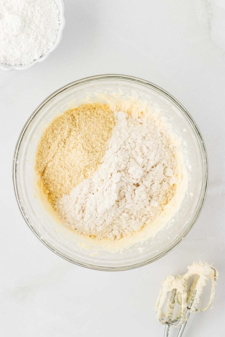 Adding almond flour and gluten-free flour to snowball cookie dough.