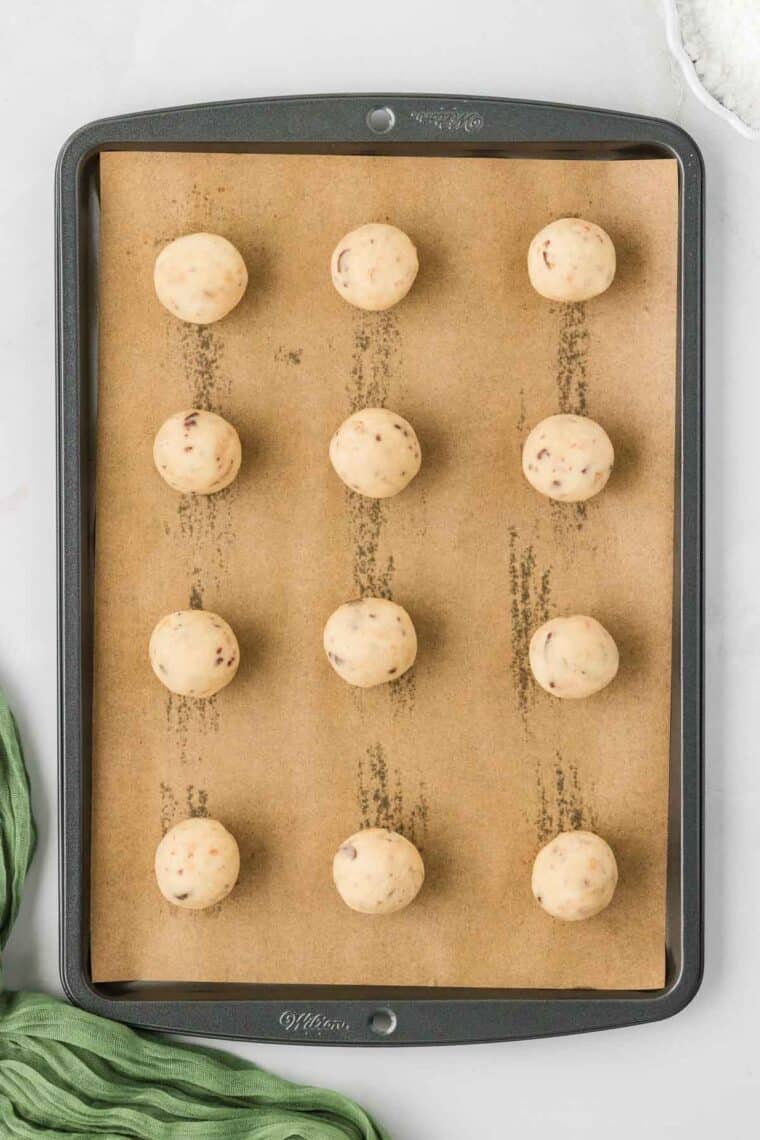 Toffee almond snowball cookie dough formed into balls and arranged on a baking sheet.