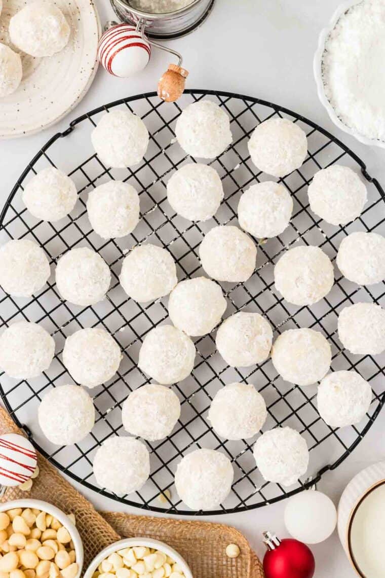 White chocolate macadamia snowball cookies arranged on a cooling rack.