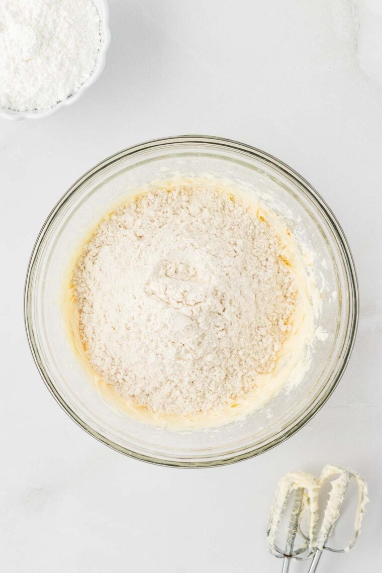 Adding flour to snowball cookie dough.