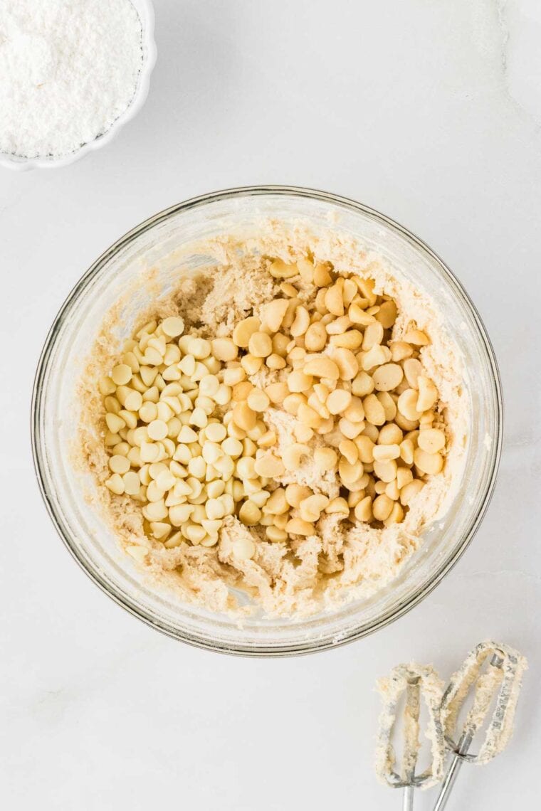 Adding white chocolate chips and macadamia nuts to snowball cookie dough.