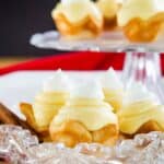 Close-up image of gluten-free eggnog pies on a serving plate with cinnamon sticks.