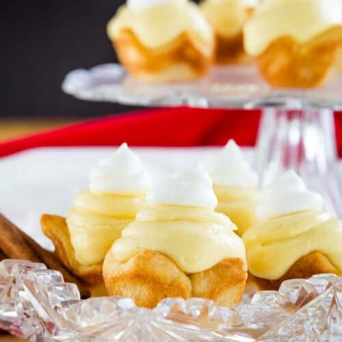 Close-up image of gluten-free eggnog pies on a serving plate with cinnamon sticks.