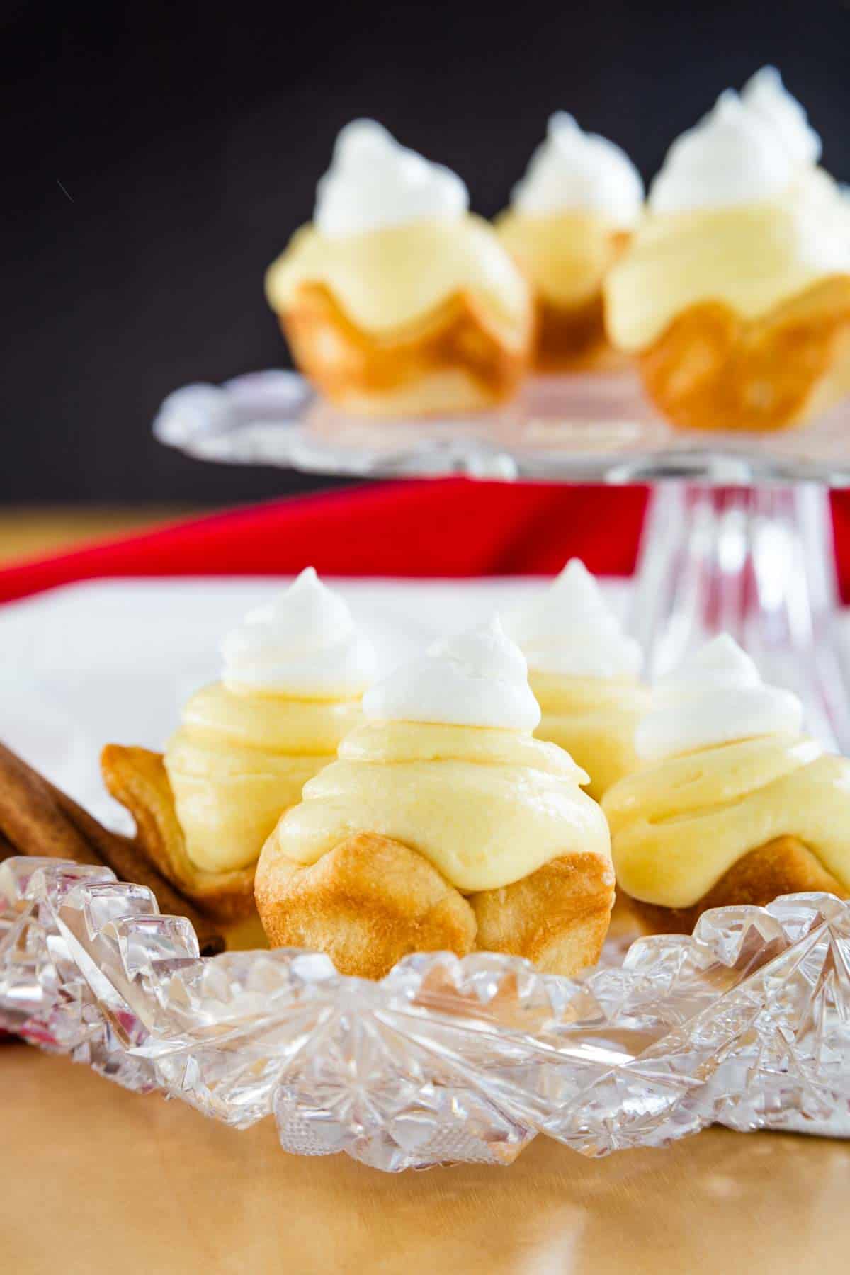 Close-up image of gluten-free eggnog pies on a serving plate with cinnamon sticks.