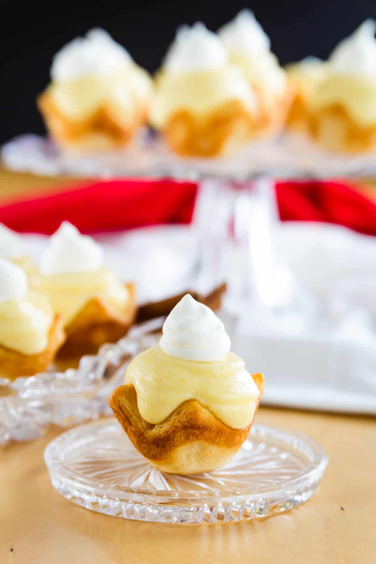 A mini eggnog pie on a serving plate with several out-of-focus pies in the background.