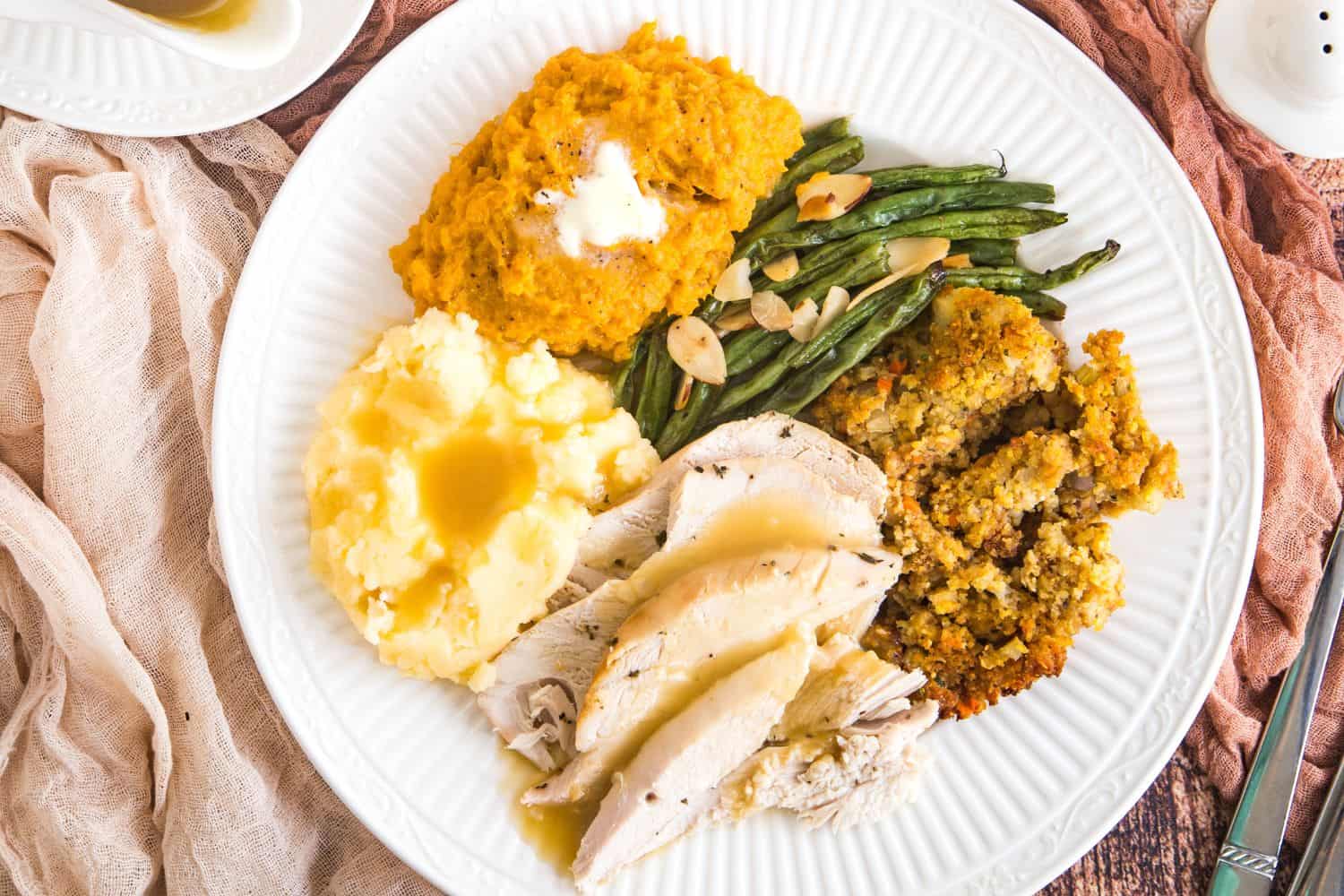 A full turkey dinner with mashed potatoes, green beans, and stuffing.