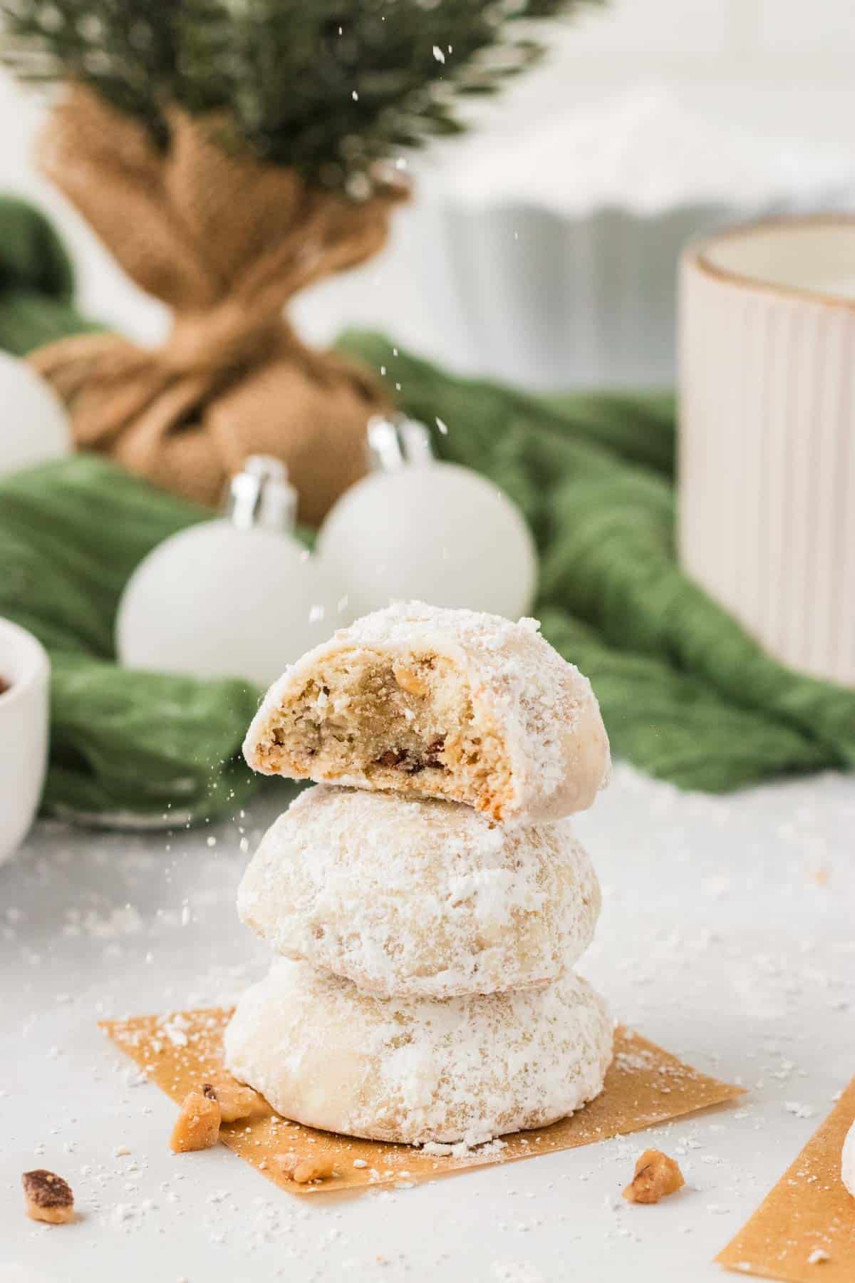 A stack of toffee almond snowball cookies. The top cookie has a bite taken out of it.