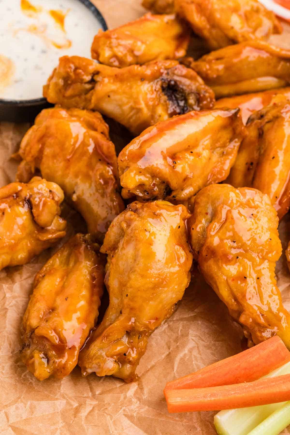 Overhead view of baked buffalo wings on a wooden cutting board