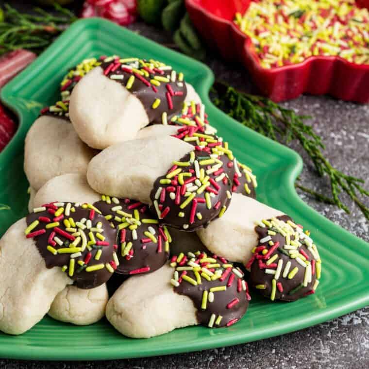 Gluten free almond crescent cookies on a dish shaped like a Christmas tree.