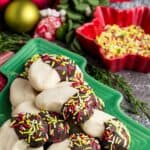 Chocolate-dipped almond crescents on a Christmas tree-shaped dish with text overlay that says "Gluten Free Almond Crescent Cookies".