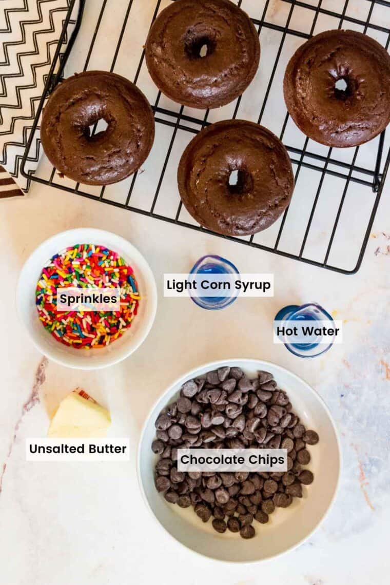 Ingredients for the chocolate for the donuts on the rack next to them with text labels on each item.