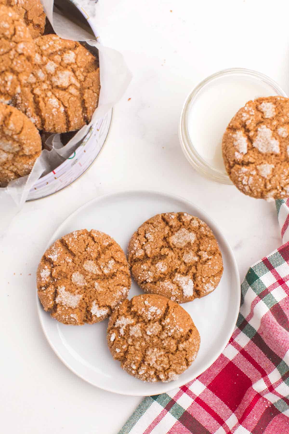 Three gingersnap cookies on a white plate.