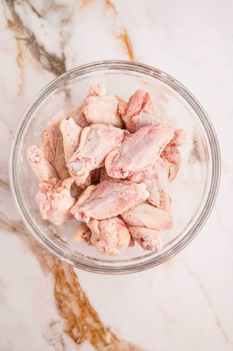 Chicken wings coated in cornstarch in a bowl
