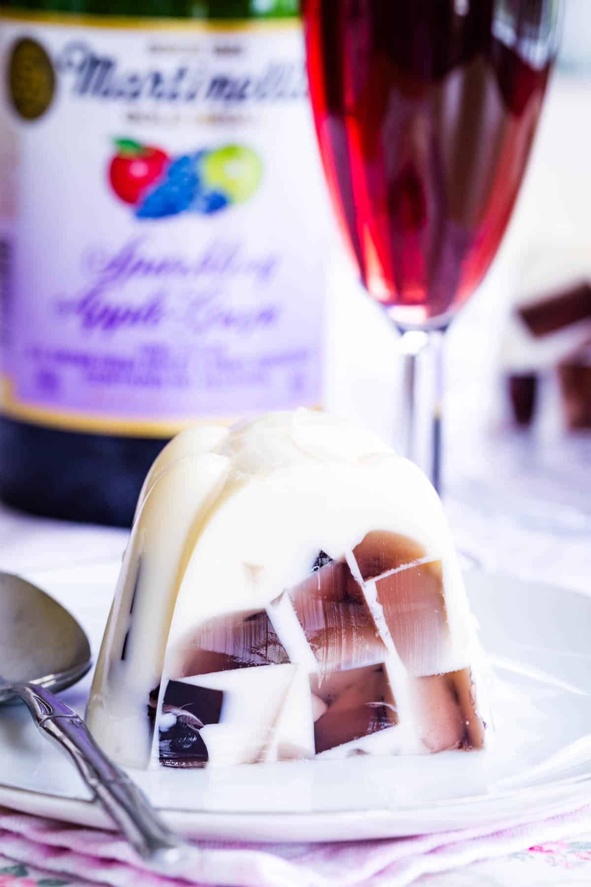 A piece of sparkling cider ice cream float jello mold on a plate with a spoon.