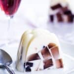 A slice of vanilla ice cream jello mold with floating sparkling cider gelatin cubes in it with text overlay that says "Ice Cream Float Jello Mold".