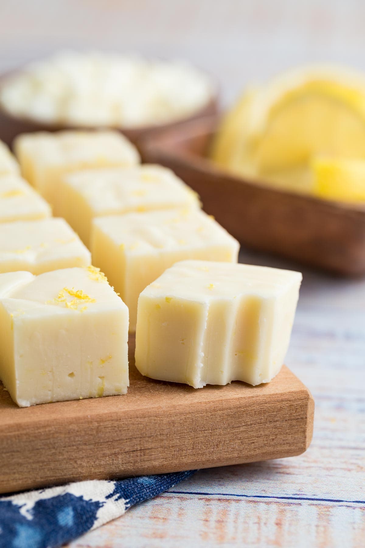 Lemon fudge on a cutting board, one piece with a bite missing