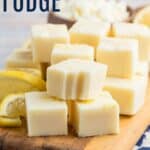 Squares of fudge on a cutting board with a bite out of one piece with text overlay that says "Lemon Fudge".