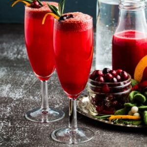 Two flute glasses with a sparkling cranberry mocktail.