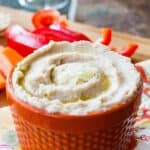 A bowl of hummus topped with oil and parmesan with text overlay that says "White Bean Truffle Hummus".